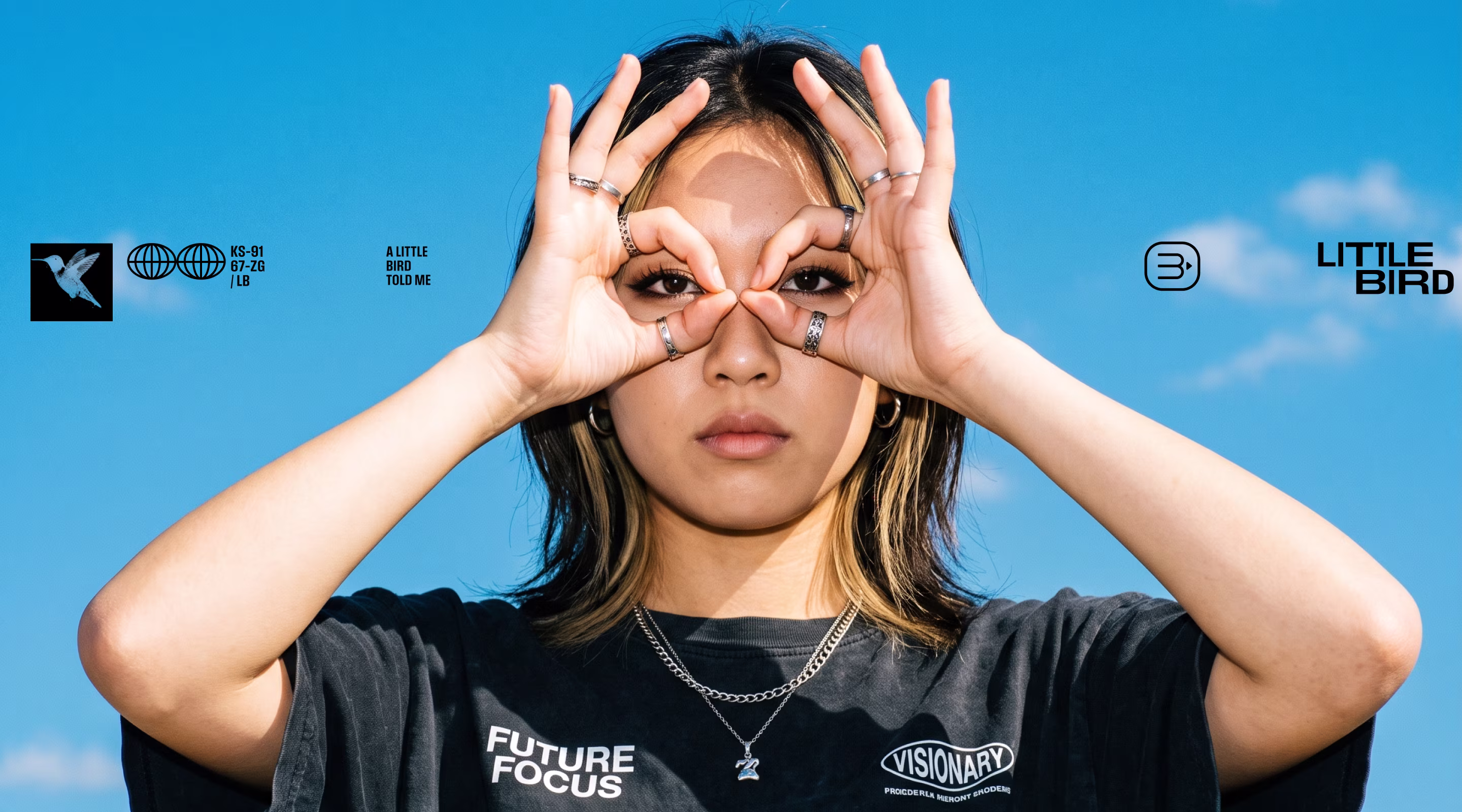 Portrait against a blue sky, with hands framing the eyes